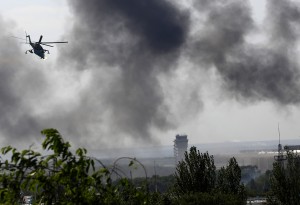 A Ukrainian helicopter Mi-24 gunship fires its cannons against rebels at the main terminal building of Donetsk international airport